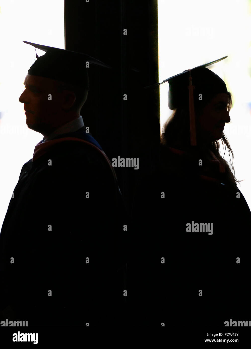 Zwei Absolventen Rücken an Rücken in 2018. Stockfoto