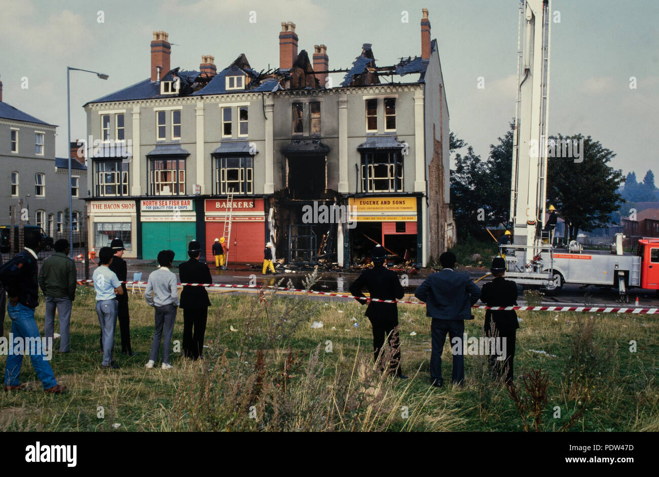 Handsworth Unruhen, Birmingham, engalnd September 1985 Die zweite handsworth Ausschreitungen fand im Handsworth Bezirk von Birmingham, West Midlands, vom 9. bis 11. September 1985. Die Unruhen waren angeblich durch die Festnahme eines Mannes, der in der Nähe des Cafe Acapulco, Lozells und eine Polizeirazzia in der Villa Cross Public House im gleichen Bereich ausgelöst. Hunderte von Menschen angegriffen und Eigentum, Plünderungen und zerschlagen, auch sie Feuer Bomben. Zwei Brüder (Kassamali Moledina, 38, und sein 44-jähriger Bruder Amirali) [1] wurden zum Tod in der Post verbrannt, dass sie liefen.[2] Zwei weitere Menschen wurden unaccou Stockfoto