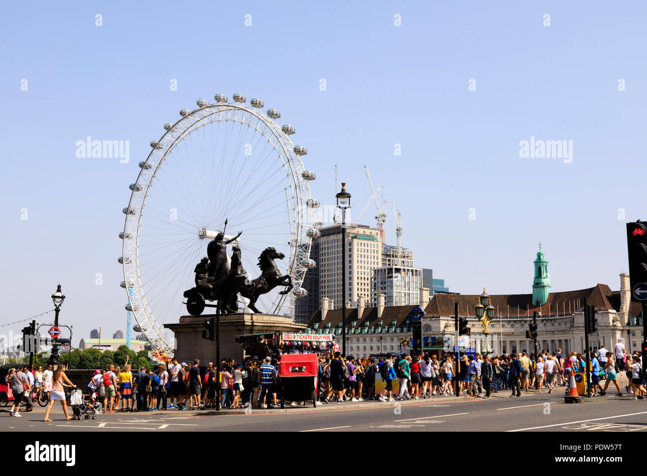 Touristenmassen auf die Westminster Bridge mit der Coca-Cola London Eye Riesenrad am Südufer der Themse, Lambeth, London, England Stockfoto
