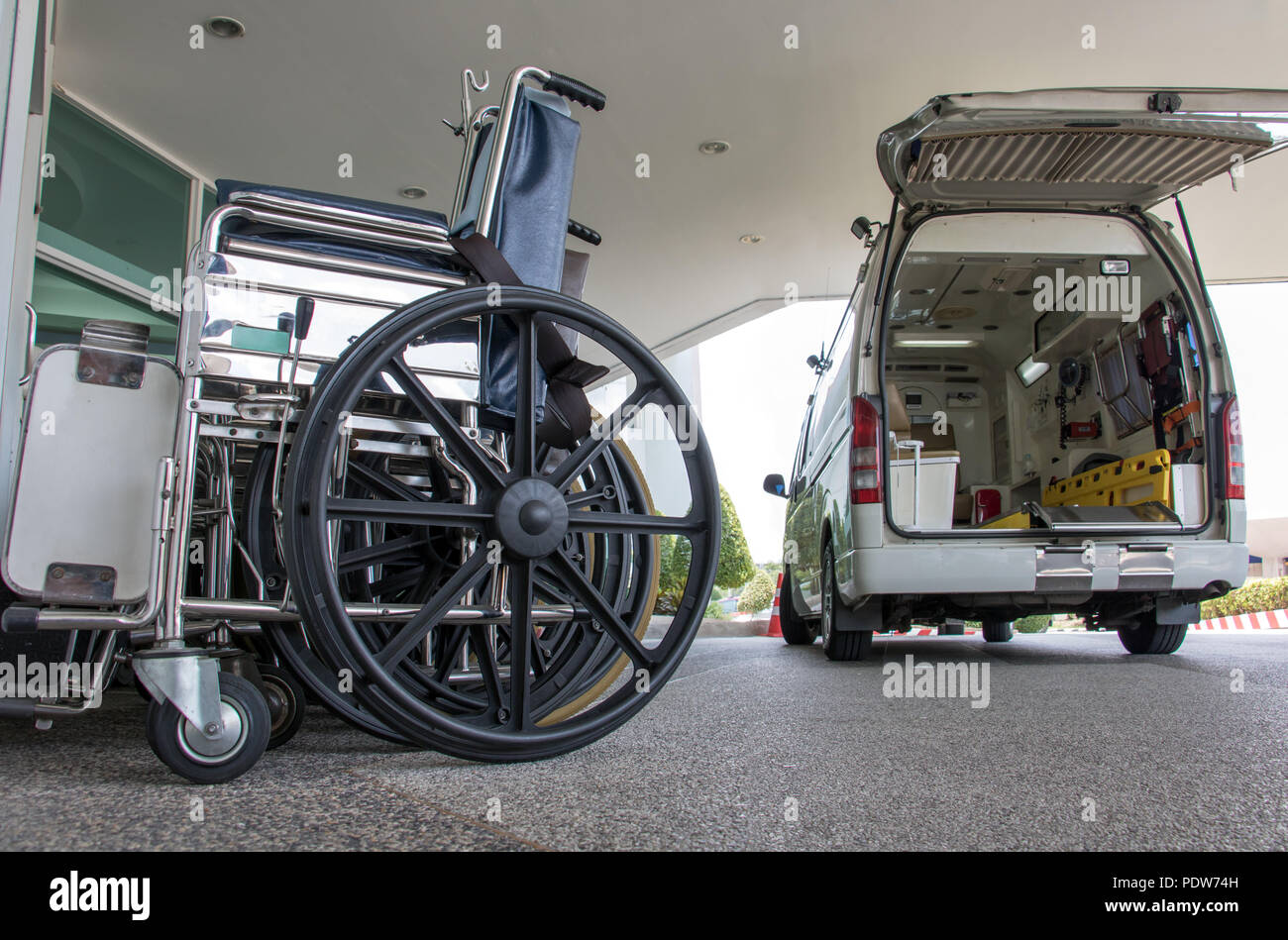 Der Krankenwagen Auto zum Eingang der Klinik angekommen. Die Rollstühle werden in einer Reihe am Eingang des Krankenhauses. Stockfoto