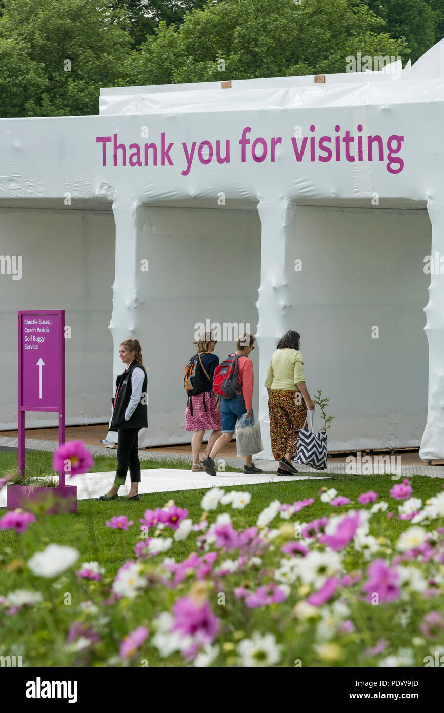 Home - Leute mit Tüten, zu Fuß in Richtung Ausgang, vorbei an der Blüte cosmos-RHS Chatsworth Flower Show, Derbyshire, England, Großbritannien Stockfoto