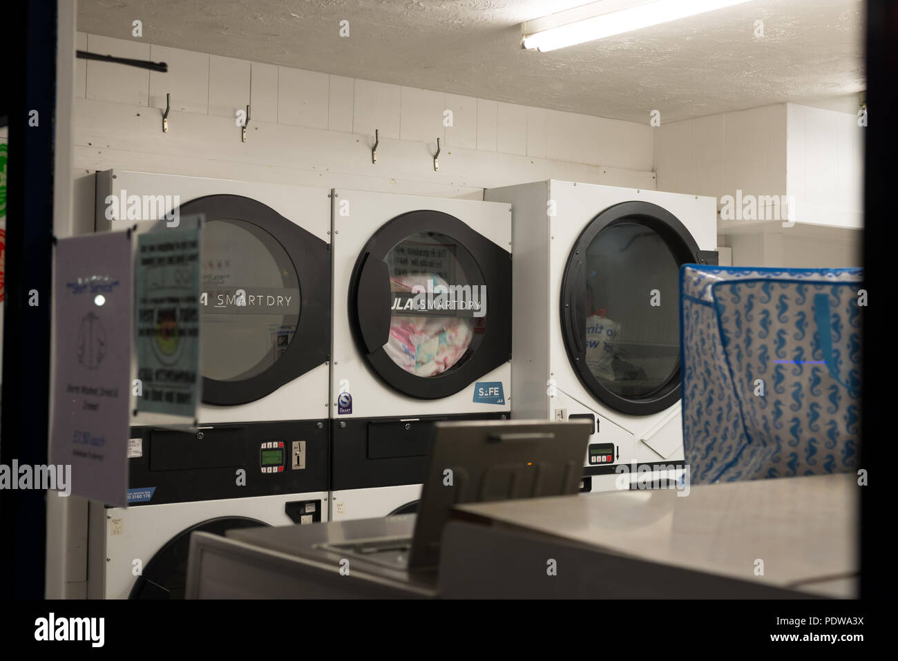 Waschsalon mit Waschmaschinen und Trockner im Chipper Lane, Salisbury, Wiltshire, England bei Nacht Stockfoto