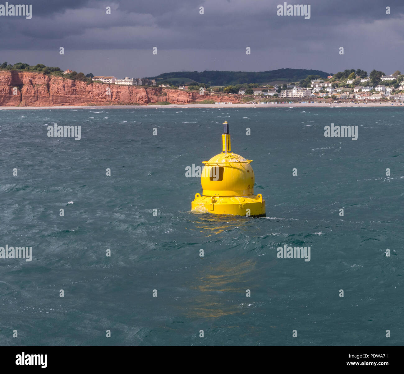 Eine tellow Boje im Meer vor der Küste von Budleigh Salterton, Devon. Stockfoto