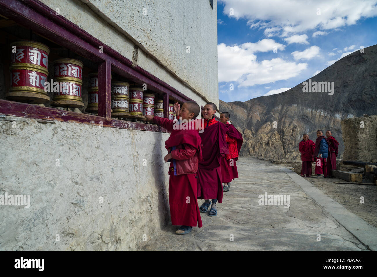 LADAKH, Indien - 6. Mai'2015: Lillte tibetische Mönche beten drehende Räder im Tempel. Dieser Tempel ist einer der heiligsten Plätze im tibetischen Buddhismus. Stockfoto