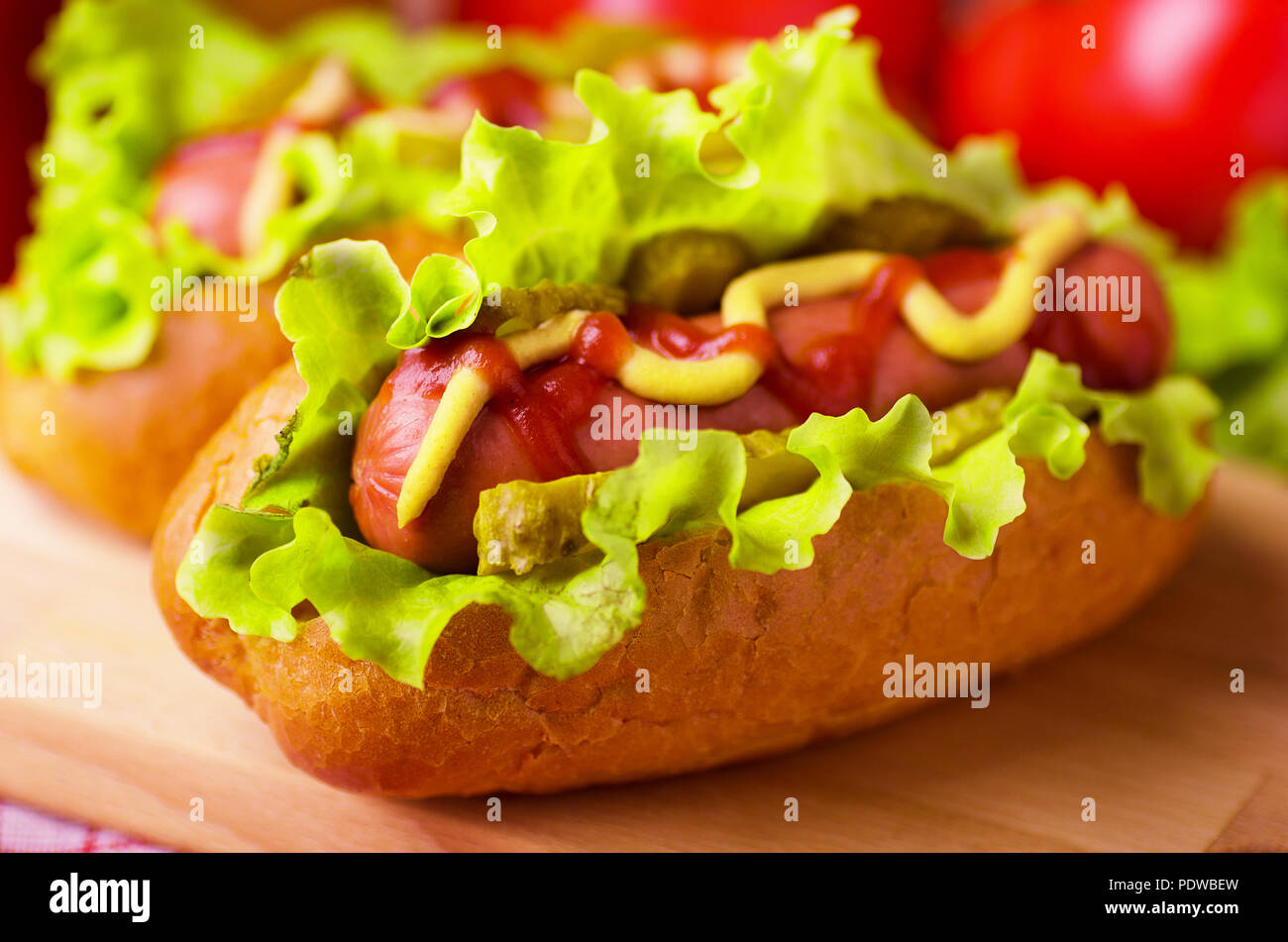 Hot Dog mit Salat, Senf und Ketchup auf hölzernen Hintergrund Stockfoto