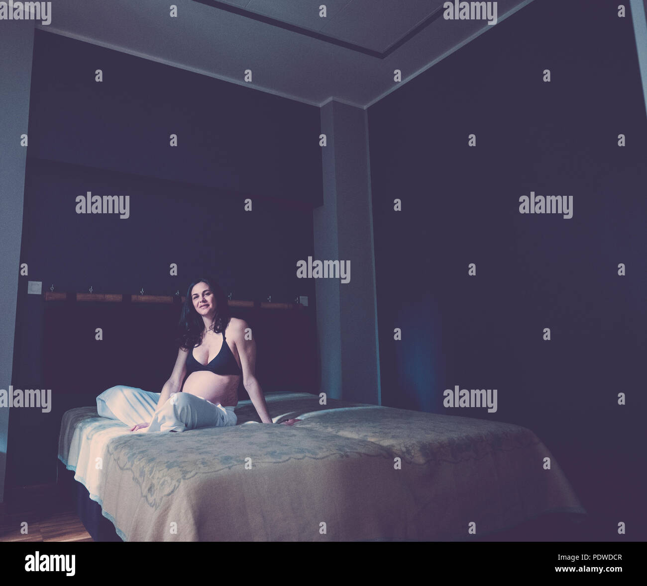 Schwangere schöne kaukasische Frau sitzt auf dem Boden und atmen zu entspannen. neues Leben Konzept zu Hause. Allein im Schlafzimmer Stockfoto