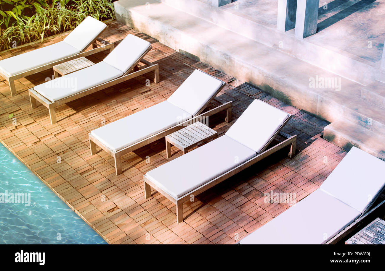 Leeren weißen Liegestühlen mock up in der Nähe von Schwimmbad in der Nähe der Luxushotels. Lounge Mockup für die Sommerferien. Sonnenliegen zum Sonnenbaden im Inn Vorlage. Stockfoto