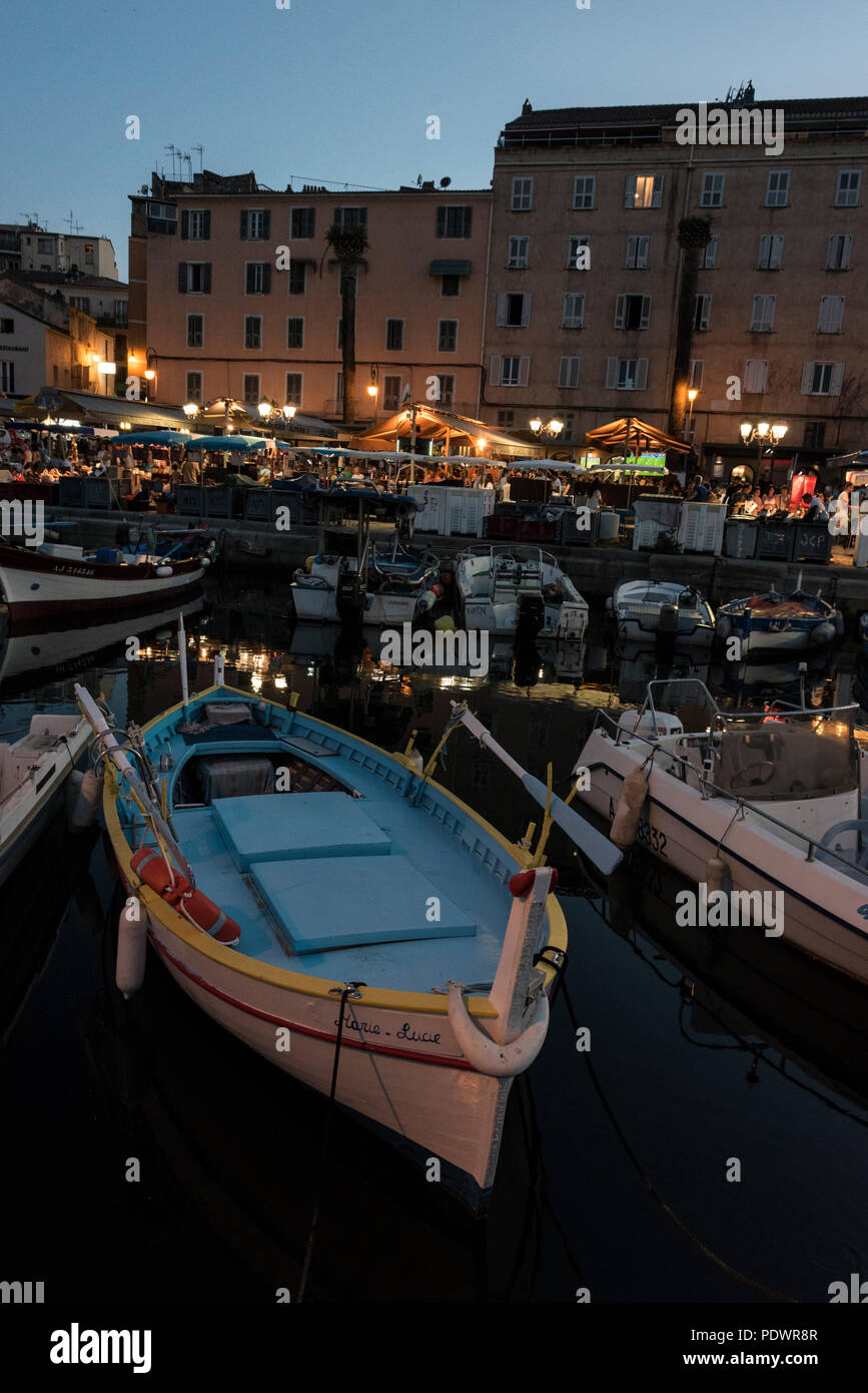 Tino Rossi Marina gefüllt mit Fischerbooten und eine Reihe von Restaurants in der Dämmerung in der alten Genueser Viertel von Ajaccio auf Korsika, Frankreich. Stockfoto