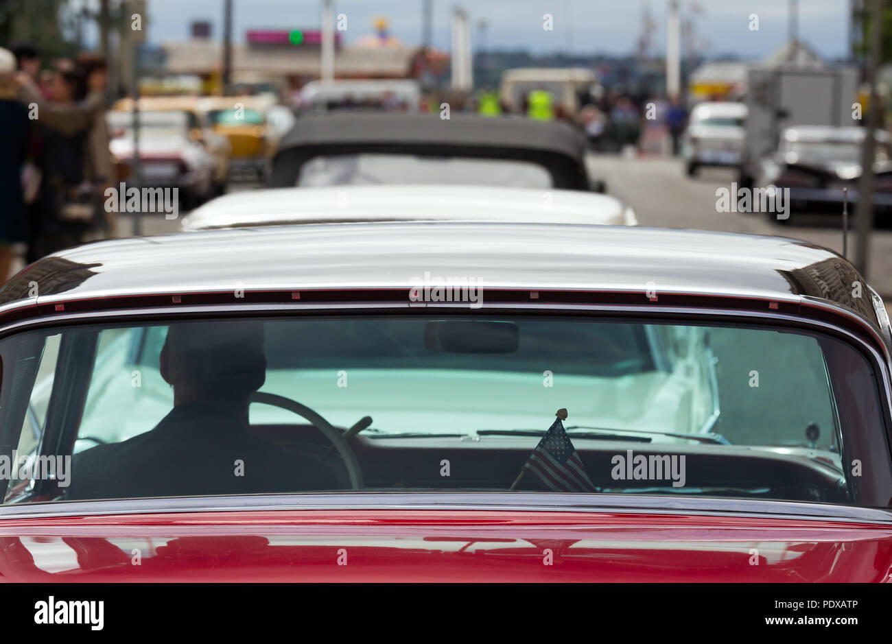 Ein Mann sitzt hinter dem Steuer eines klassischen Amerikanischen Auto auf einem Filmset, in Liverpool UK geschossen, auf Washington DC USA Stockfoto