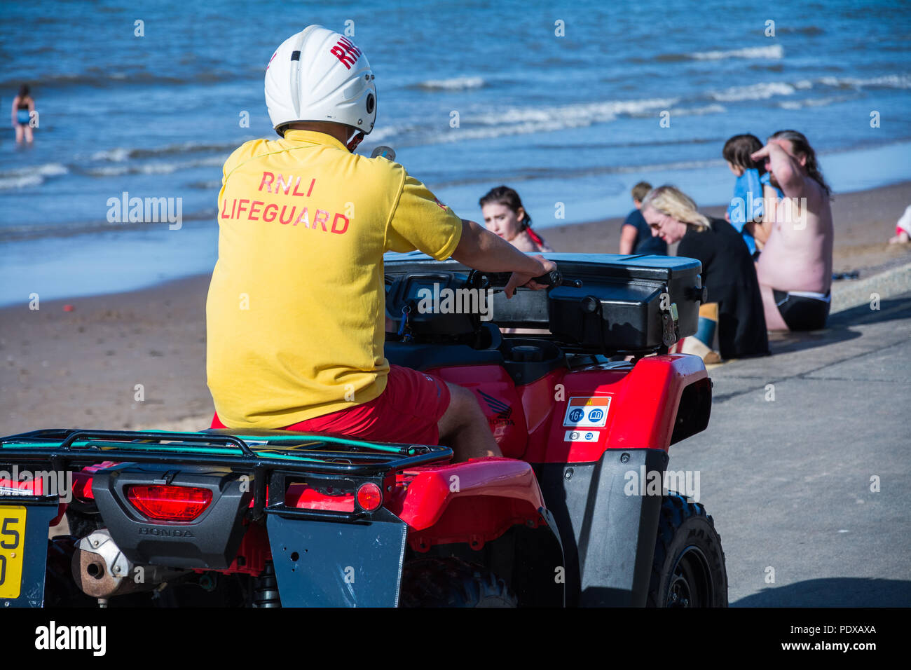 RNLI Rettungsschwimmer auf einem Quad patrouillierten Strand, Prestatyn, North Wales, UK, während der Hitzewelle im Sommer 2018. Stockfoto