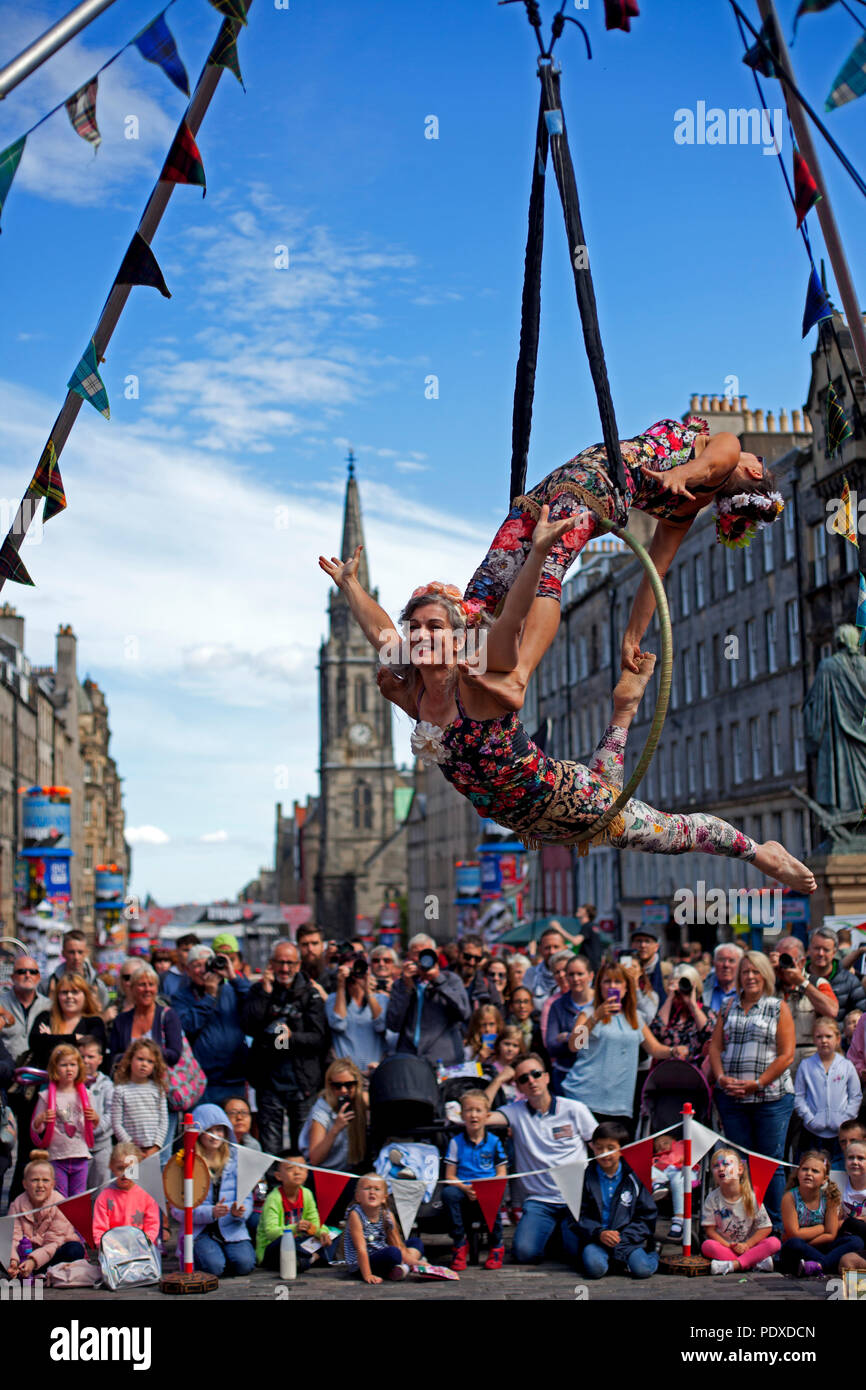 Edinburgh, Schottland, Großbritannien, 10. August 2018, Edinburgh Fringe Festival auf der Royal Mile, Antenne Trapezkünstlern schlangenmenschen das Publikum in der Sonne unterhalten. Stockfoto