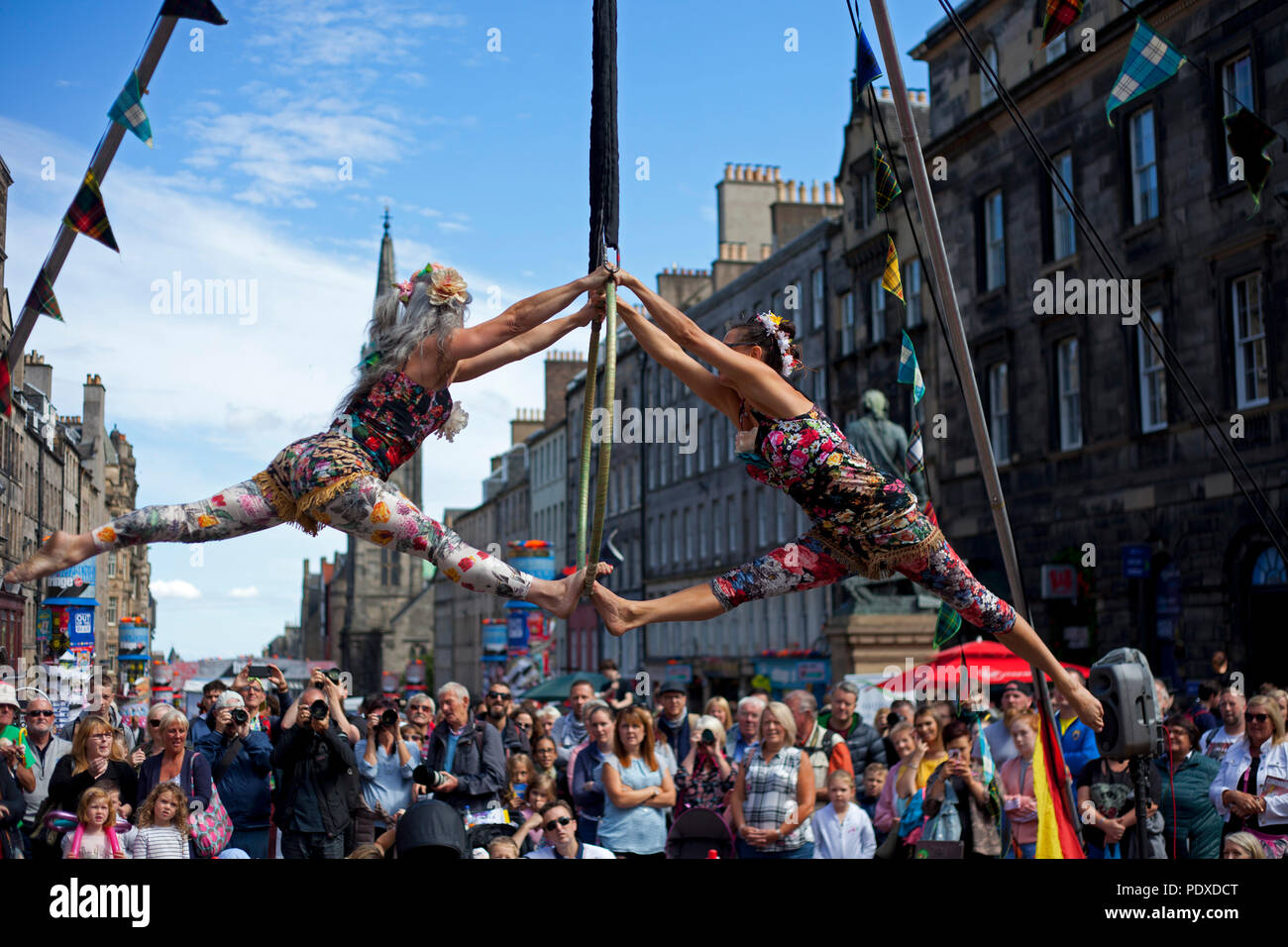 Edinburgh, Schottland, Großbritannien, 10. August 2018, Edinburgh Fringe Festival auf der Royal Mile, Antenne Trapezkünstlern schlangenmenschen das Publikum in der Sonne unterhalten. Stockfoto