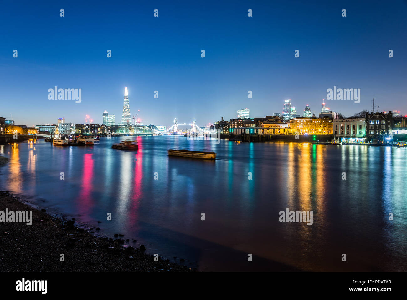 Die Londoner Skyline bei Nacht als vom Ufer der Themse in Rotherhithe gesehen Stockfoto