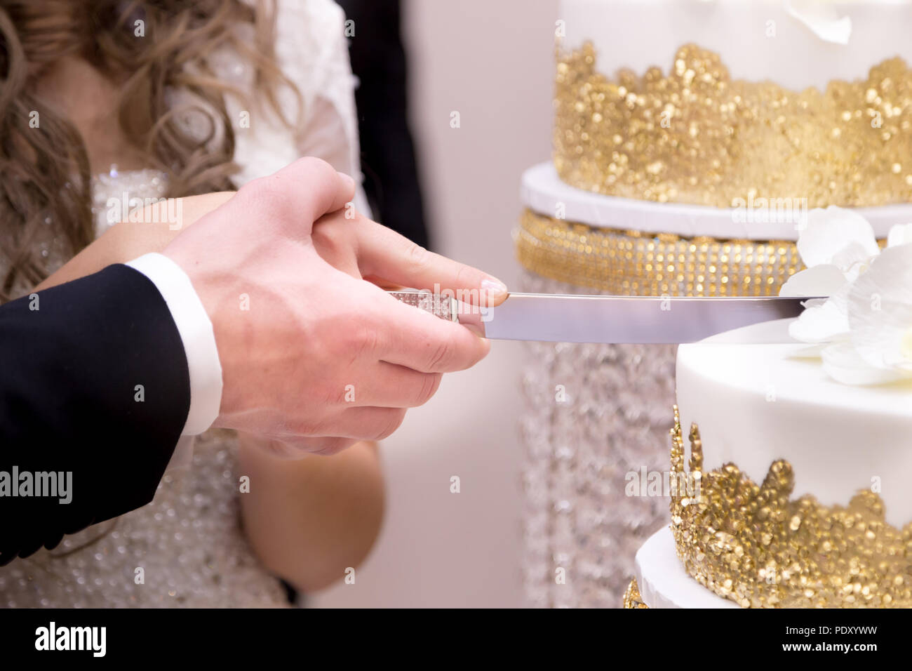 Nahaufnahmen der Hände ist ein Jungvermähltes Paar schneiden Ihre Hochzeitstorte. Stockfoto