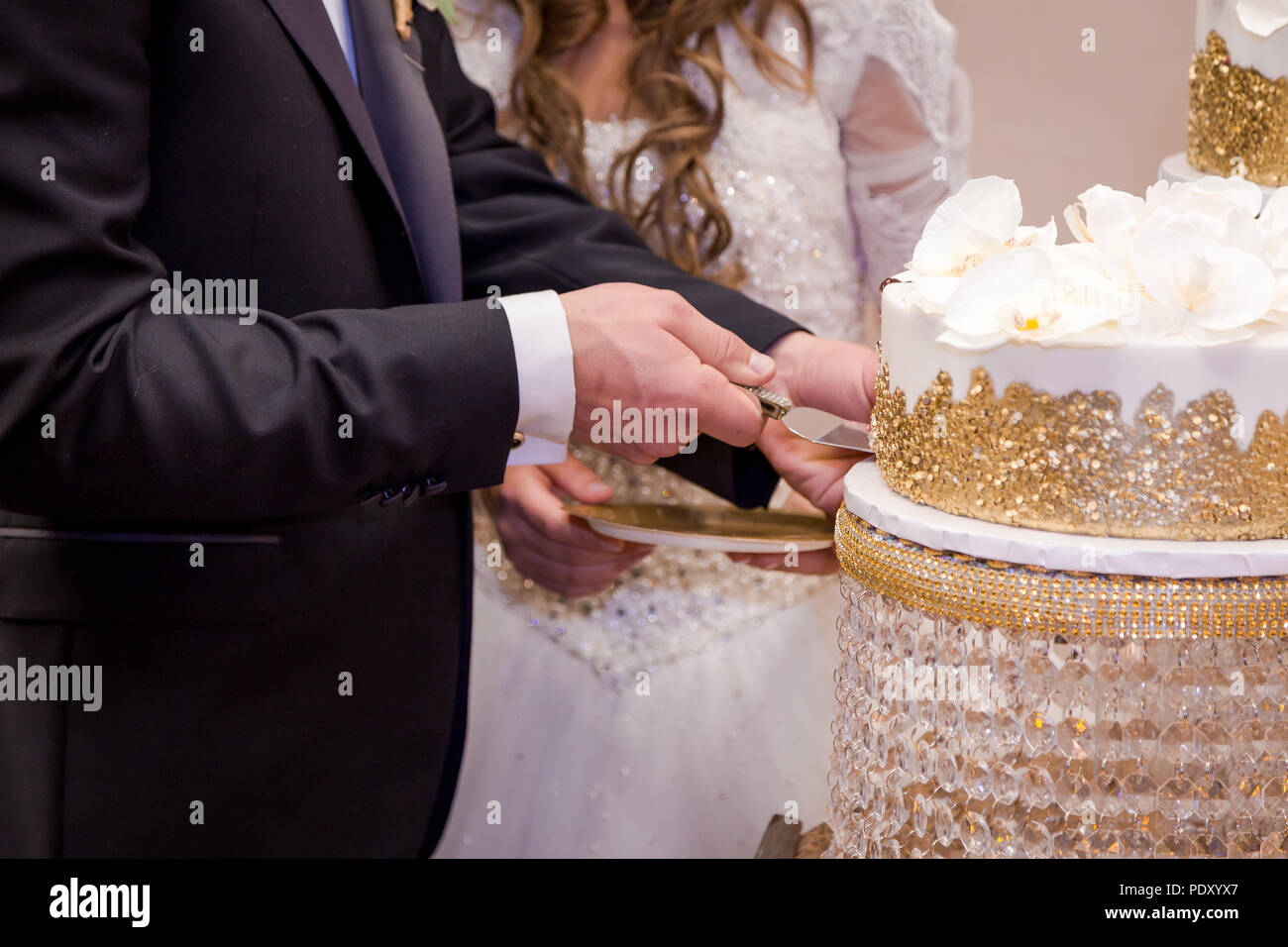 Nahaufnahmen der Hände ist ein Jungvermähltes Paar schneiden Ihre Hochzeitstorte. Stockfoto