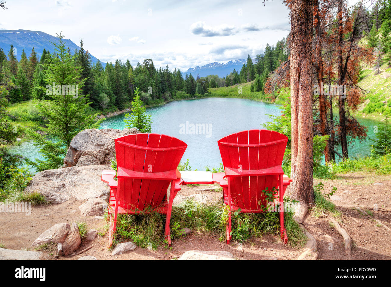 Zwei rote Adirondack Stühlen mit Blick auf das Tal der fünf Seen am Icefields Parkway in den kanadischen Rockies. Sie wurden von Parks Canada platziert Stockfoto