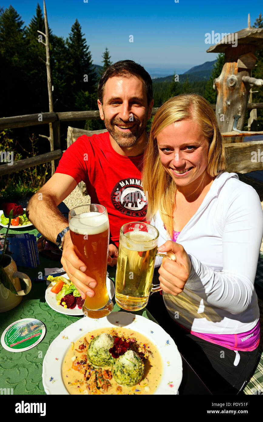 Wanderer Paar genießen Sie einen Snack auf der Hindenburghütte, Reit im Winkl, Chiemgau, Oberbayern, Deutschland Stockfoto