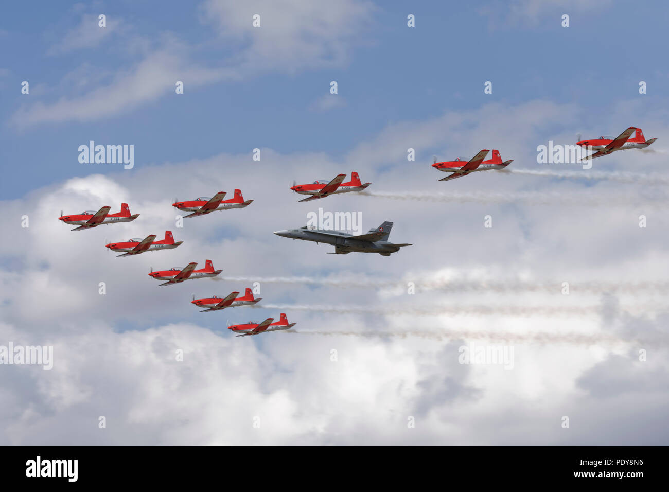 Die Swiss Air Force Aerobatic Display Team in Ihren PC-7 Turbotrainers fliegen in Formation mit einem Schweizer F/A-18C Hornet bei der RIAT Stockfoto
