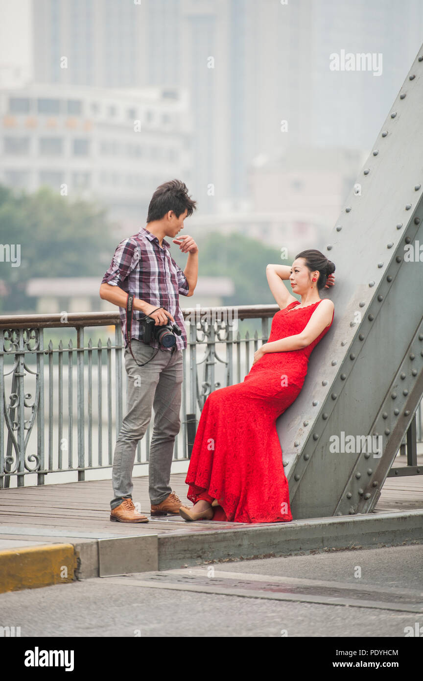 Shanghai, China - 20. Oktober 2014. Fotograf und ein weibliches Model beim Fototermin auf einer Brücke über den Fluss Huangpu in Shanghai. Stockfoto