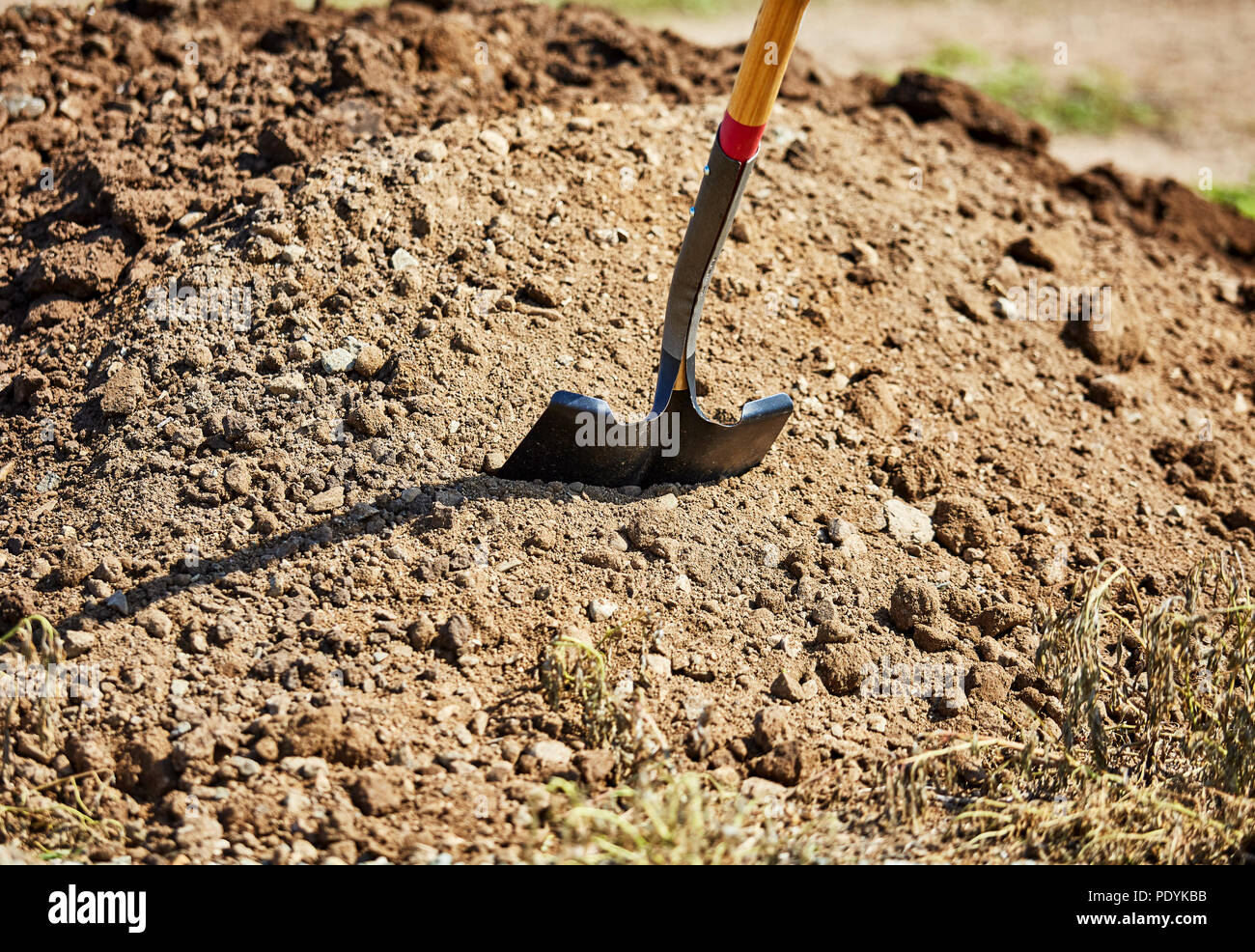 Nahaufnahme von einer Schaufel in einen Erdhaufen klemmt Stockfoto