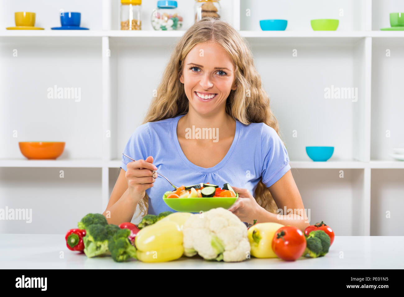 Schöne Mädchen genießt Essen Salat an ihrem Haus. Stockfoto