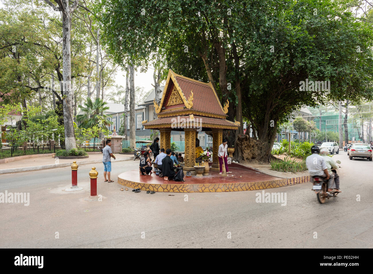Kambodschanischen Anbeter vor König Master Statue beten unter einem Baum und in der Mitte der Straße, Siem Reap, Kambodscha Stockfoto