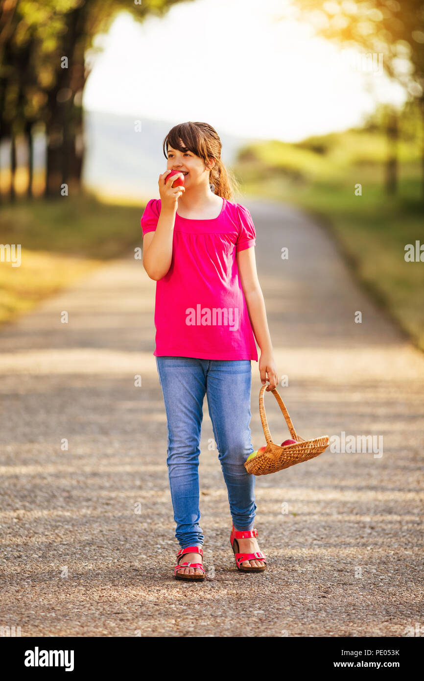 Schöne Mädchen genießt Essen Apple bei einem Spaziergang in der Natur. Bild absichtlich abgeschwächt ist. Stockfoto