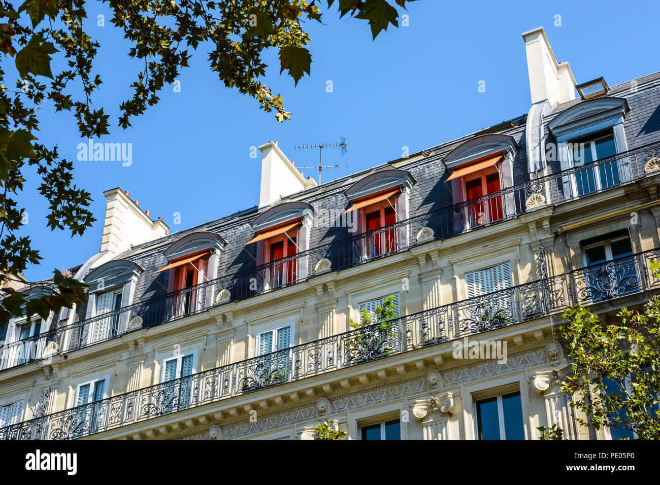 Blick von unten auf der Straße von einem typischen Pariser, opulent - Gebäude von Haussmann-gebäude Stil mit geschliffenen Steinen Fassade suchen, geschnitzten Ornamenten und Balkon. Stockfoto