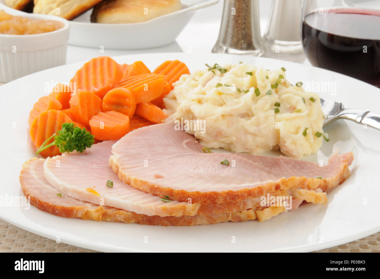 In Scheiben geschnitten gebackener Schinken mit gestampften Kartoffeln und Karotten Stockfoto
