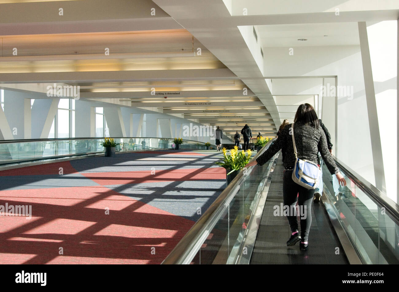 Passagiere, die über eine Airport concourse Flugzeuge am Morgen Stockfoto