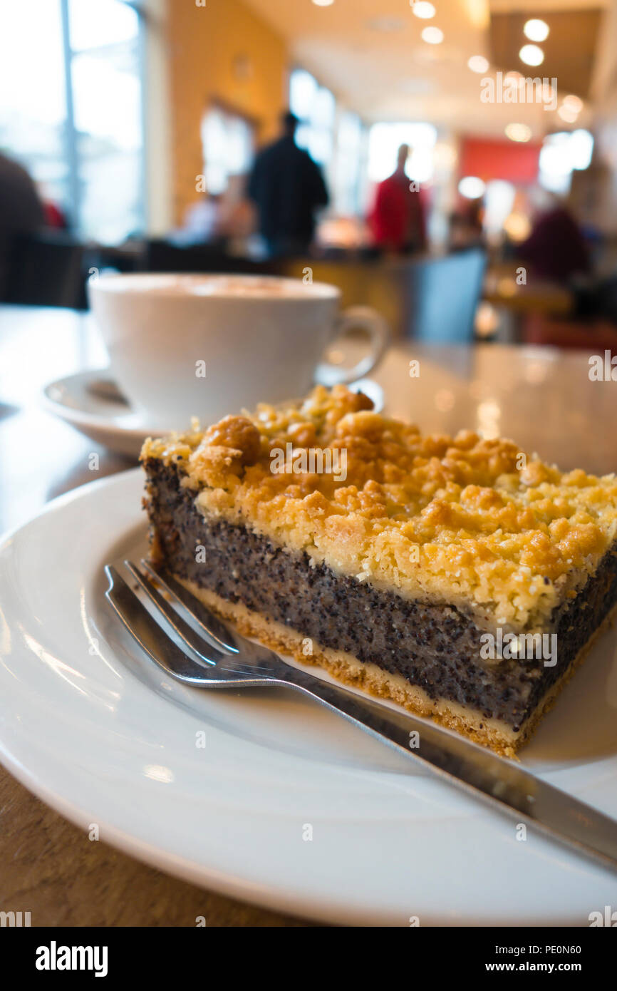 Leckere süße bereit Dessert Kuchen aus Mürbeteig mit Kaffee und Nüsse zu essen steht auf einer Keramikplatte auf dem Tisch neben Tasse Kaffee ich Stockfoto