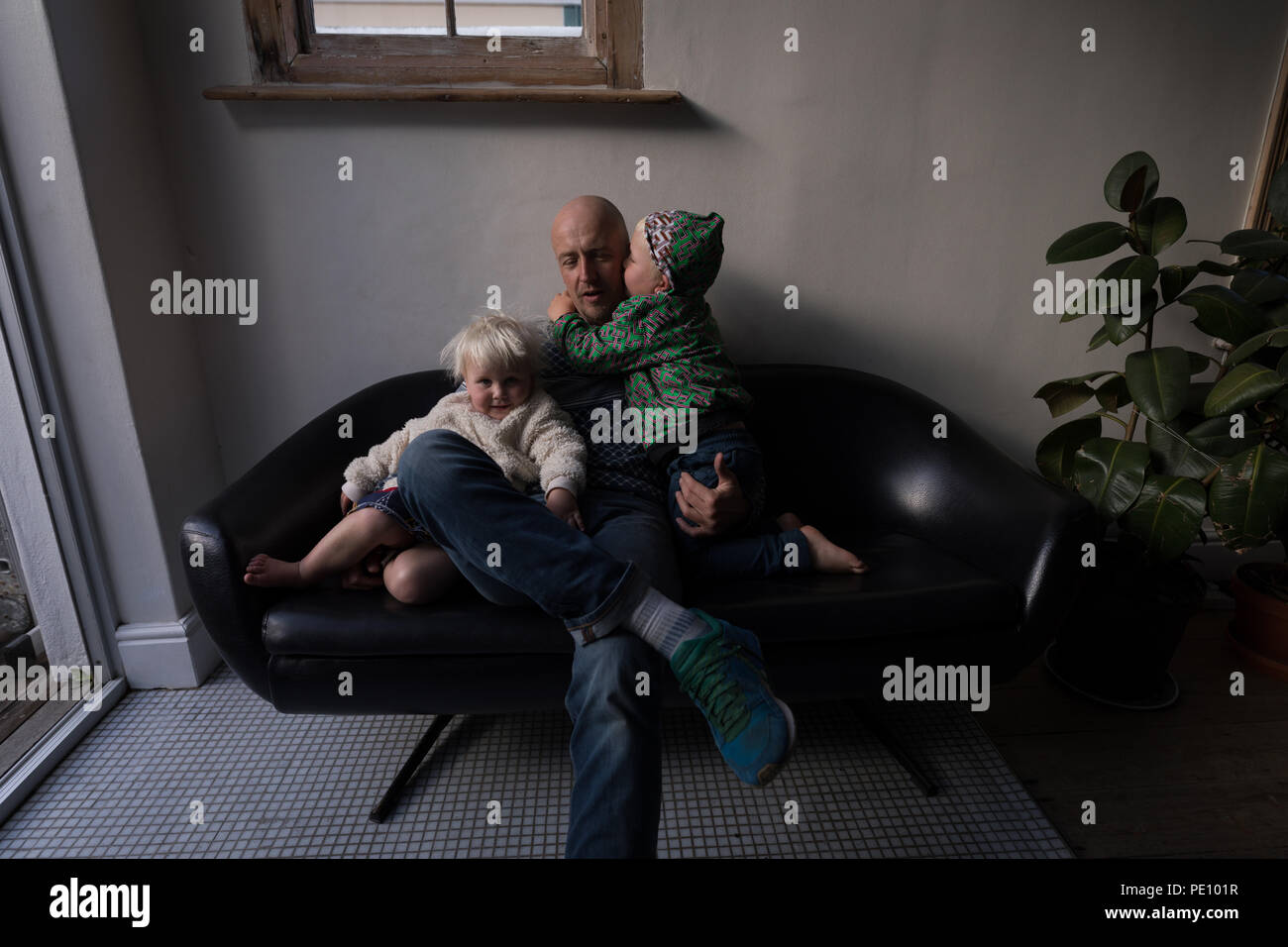 Vater mit seinen Kindern im Wohnzimmer Stockfoto