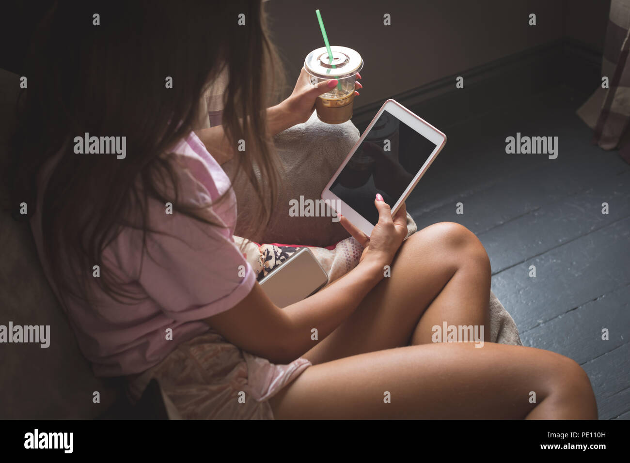 Mädchen mit Handy, während Sie einen kalten Kaffee Stockfoto