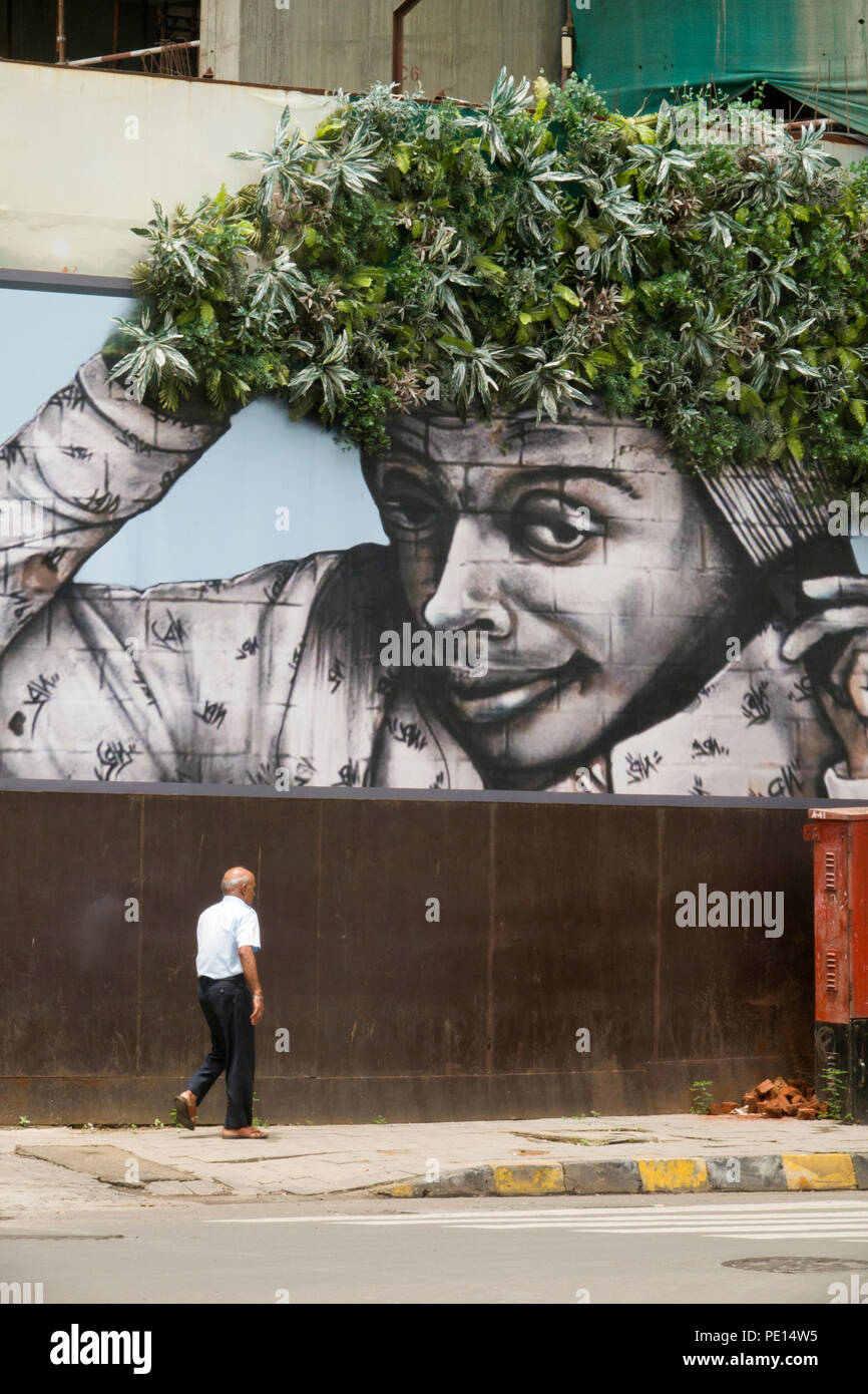 Fußgänger vorbei leben Wandbild in Mumbai street scene Stockfoto