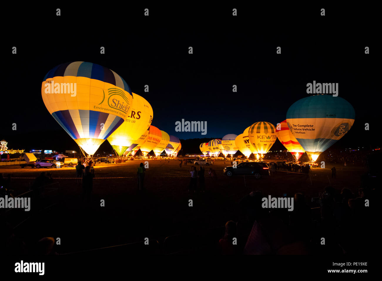 Nacht Leuchten am Abend des Bristol International Balloon Fiesta. Eine Reihe von Ballons in der Nacht Musik mit ihren Gasbrenner durchgeführt Stockfoto