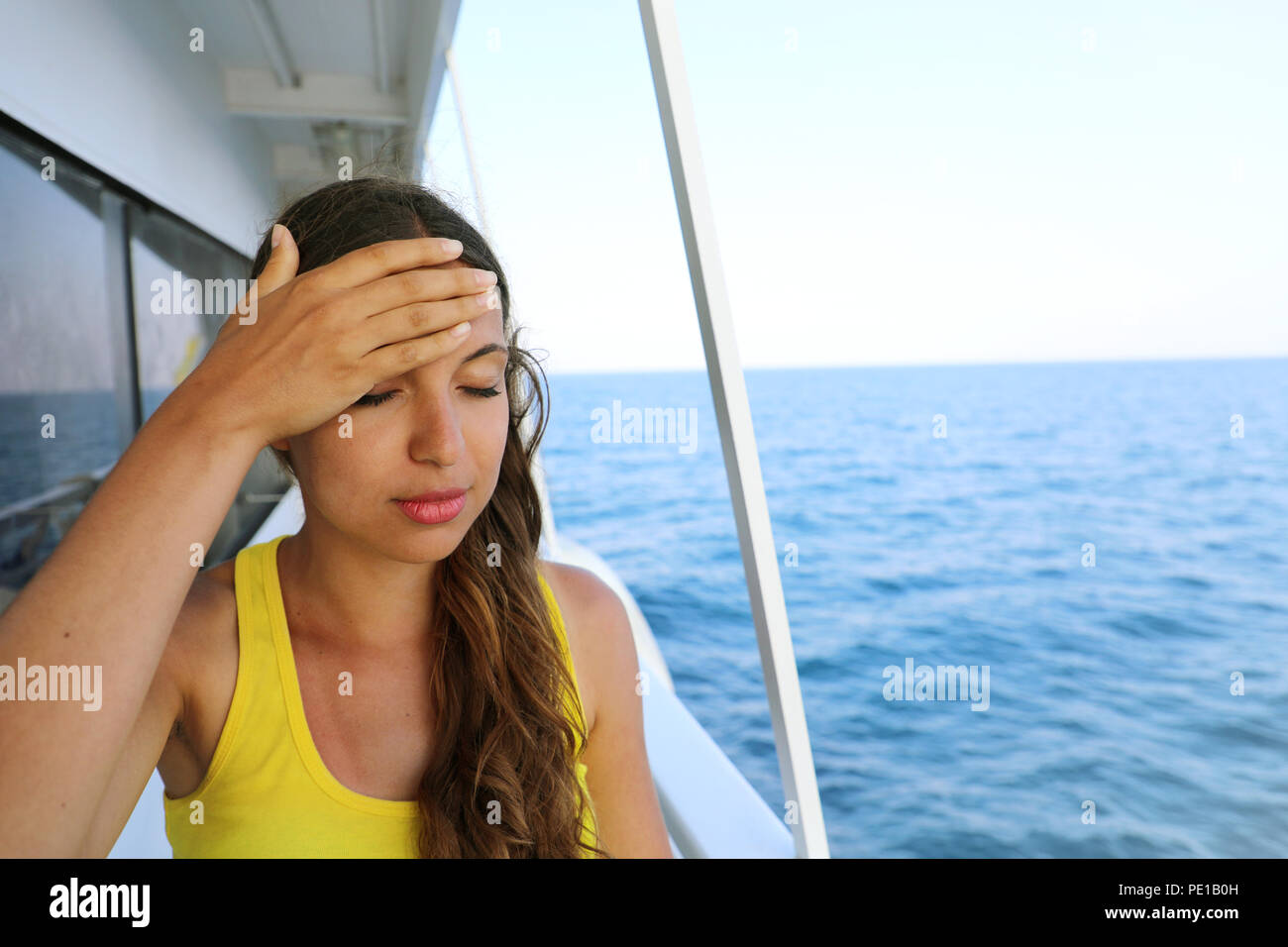 Junge Frau leiden unter Seekrankheit während der Ferien auf dem Boot. Kreuzfahrt meer Reisekrankheit touristische Frau auf Boot Urlaub mit Kopfschmerzen oder Übelkeit. Stockfoto