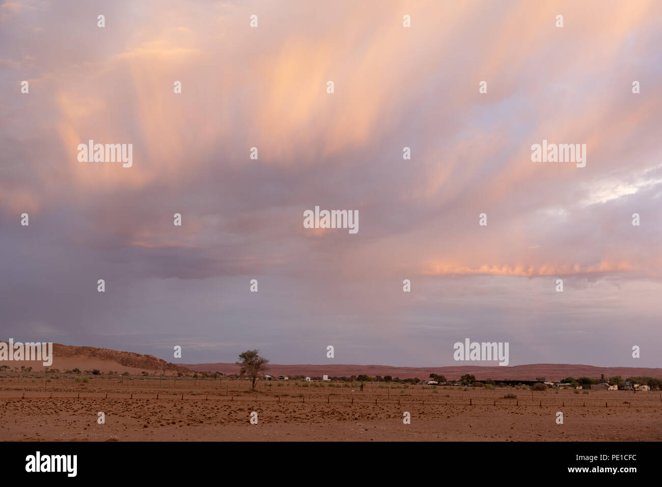 Schöne Sonne beleuchtet stürmischen cloudscape über ein Dorf in der Wüste, Namibia Stockfoto