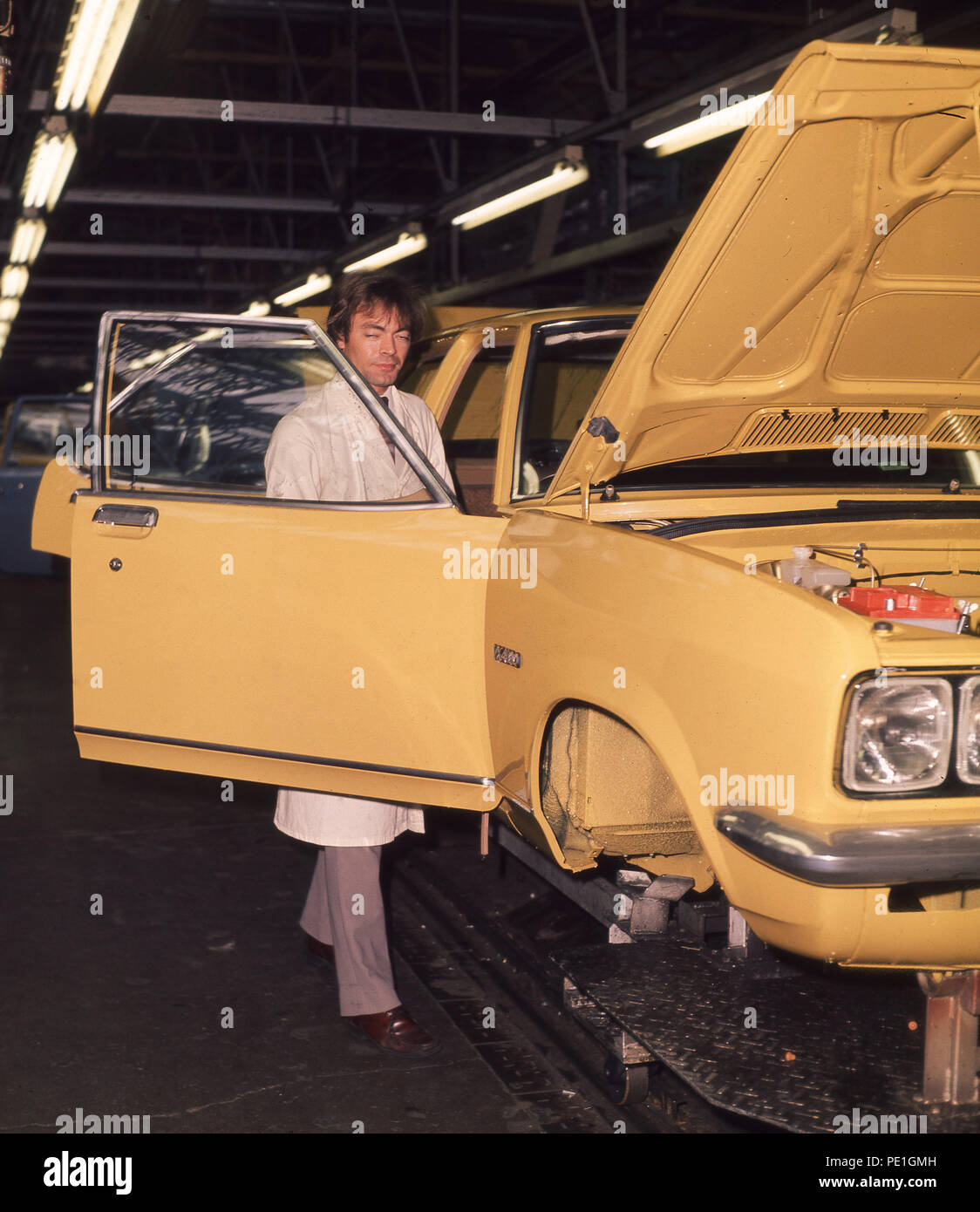 1970 s, Vauxhal Automobilwerk, Bedford, Luton, England, UK. Hersteller des Viva Modell, Bild zeigt einen weiß beschichteten männlichen Inspektor Kontrolle der teilweise zusammengebaut lackiert motorcar. Stockfoto