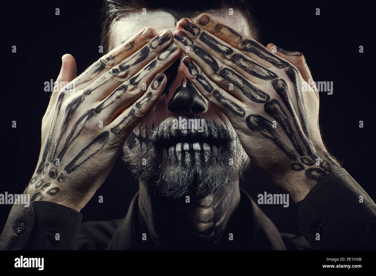 Porträt eines Mannes mit Halloween Skull Make-up auf der Schwarzen backgro Stockfoto