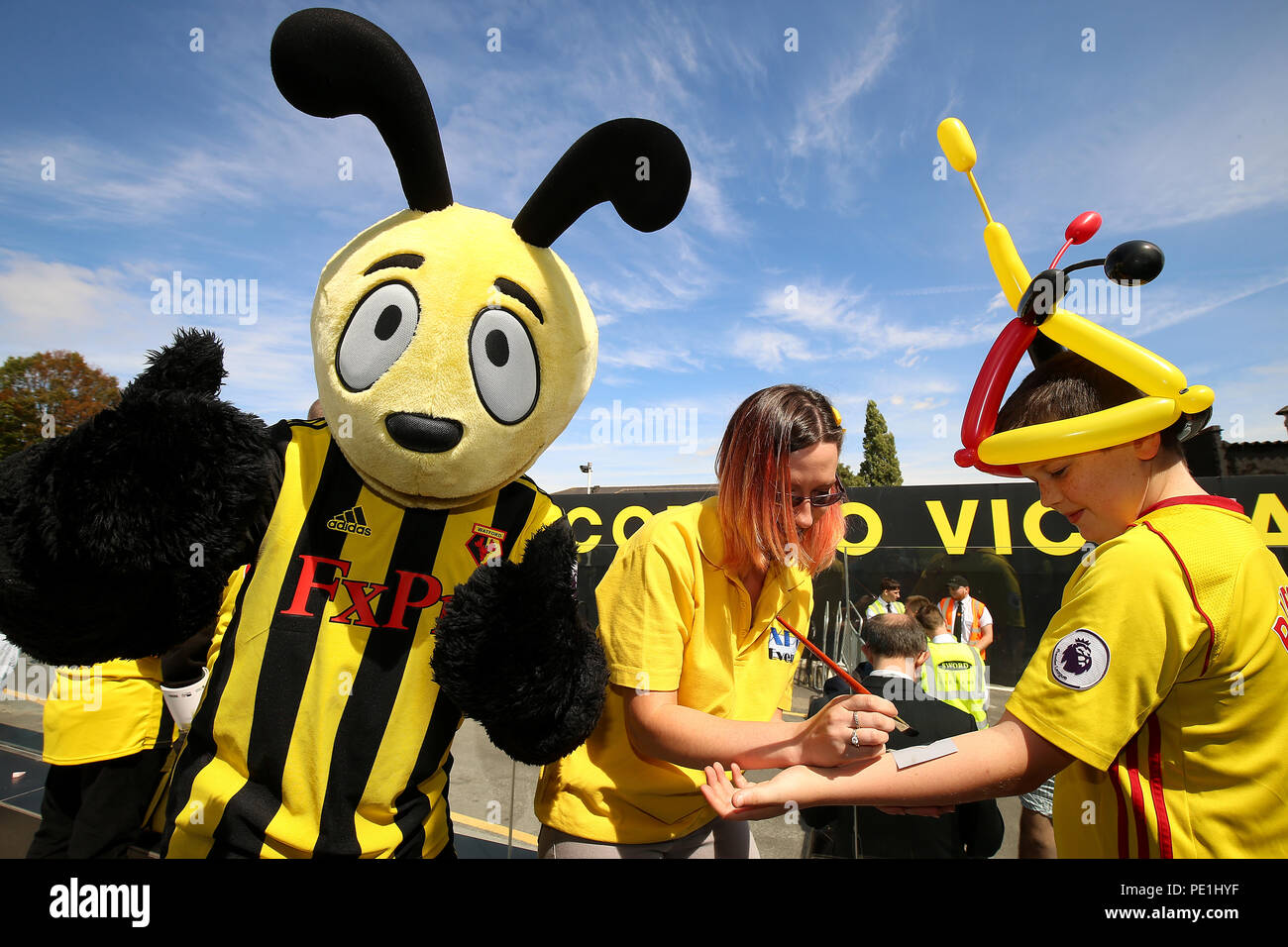 Watford Maskottchen Harry Hornissen als Watford Ventilatoren erhalten temporäre Tattoos vor der Premier League Match an der Vicarage Road, Watford gemalt. Stockfoto