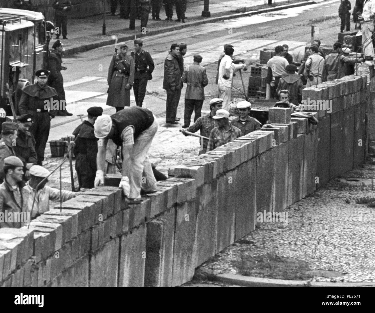 Eingereicht - 18. August 1961, Deutschland, Berlin: Unter der Aufsicht von der bewaffneten Polizei, Ost Berliner Maurer bauen eine Mauer am Potsdamer Platz an der sowjetisch-US-Sektor Kreuzung. Am 13. 13. August 1961, der Bau der Mauer begann, die Berlin für mehr als 28 Jahre lang geteilt. Foto: UPI/UPI dpa/dpa Stockfoto