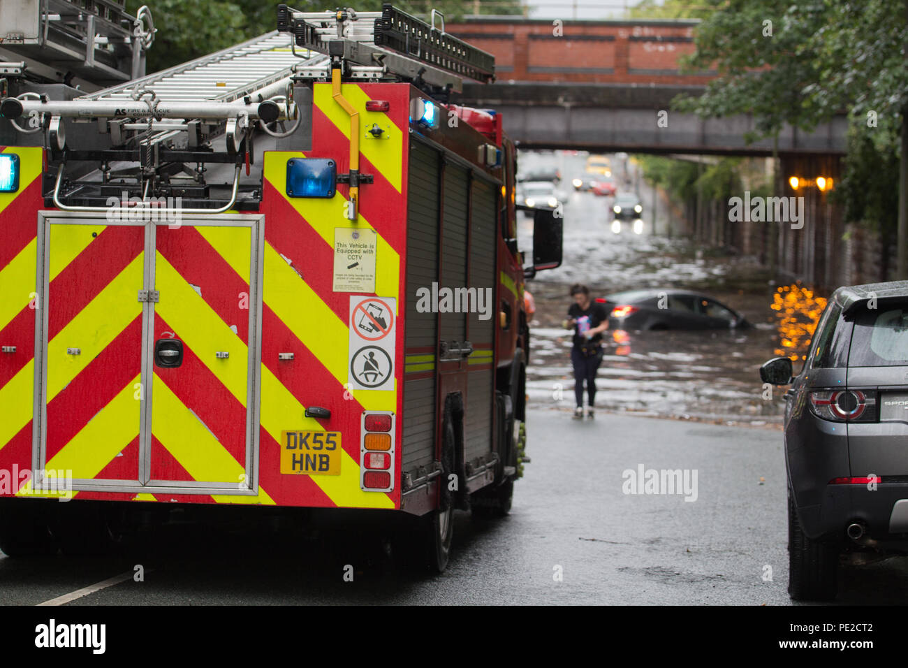 Liverpool, Großbritannien. 12 August, 2018. UK Wetter. Junge Paare sind in Ihrem Auto eingeschlossen, nachdem Überschwemmungen Liverpool schlagen. Die Paare wurden auf Queens Drive L 18 auf einem berüchtigten Sprung in der Straße gefangen, nach dem Kampf gegen das steigende Wasser sie schließlich durch das Wasser wateten gerade als die Feuerwehr eintraf. Credit: Ken Biggs/Alamy Leben Nachrichten. Stockfoto