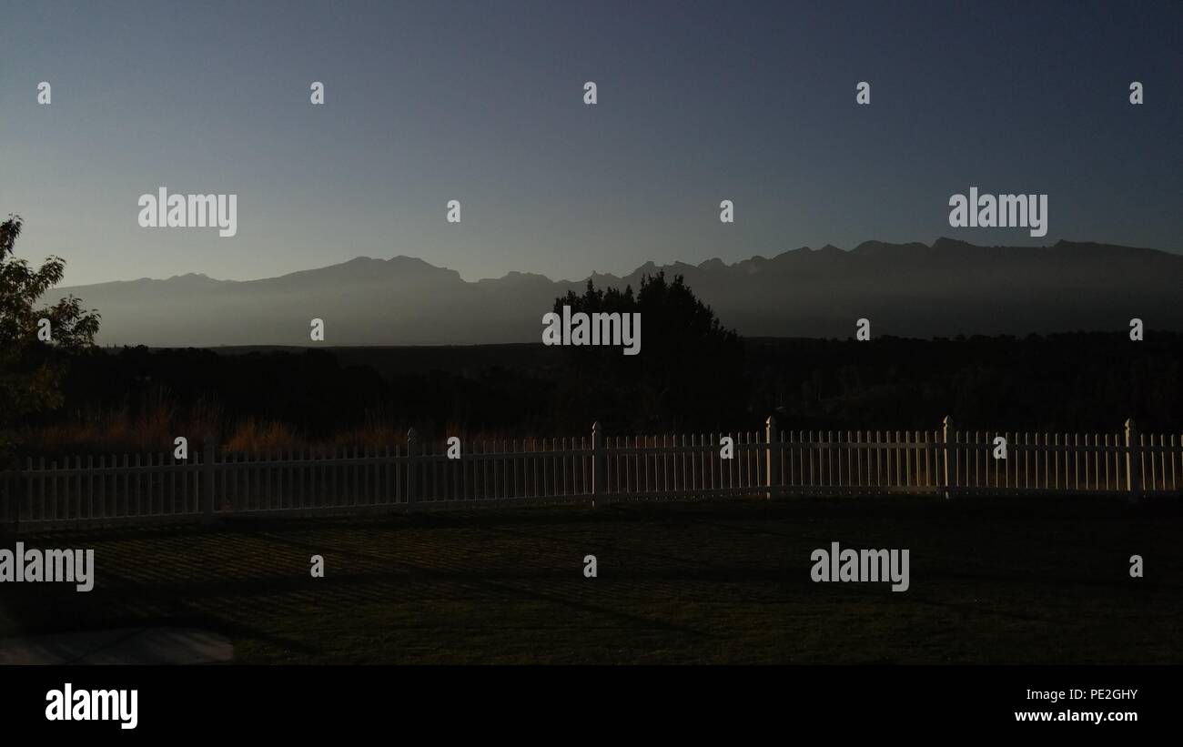 Sonnenaufgang Blick auf einen weissen Lattenzaun Stockfoto