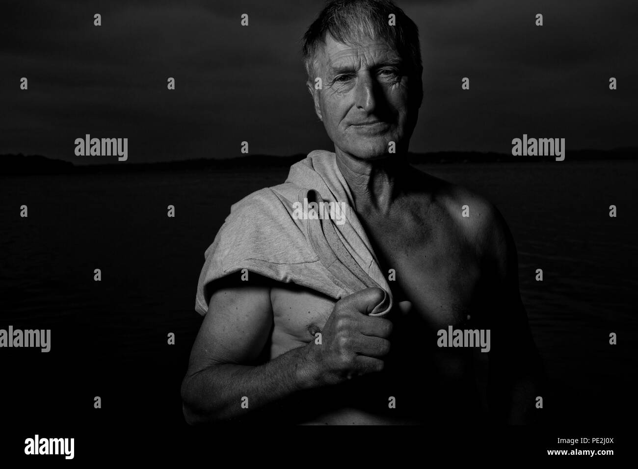 Mitte - Alter Mann bei einem Spaziergang am Strand bei Dämmerung Stockfoto
