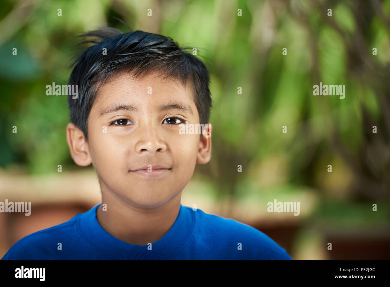 Portrait von Latino boy an sonnigen verschwommenen Hintergrund Stockfoto