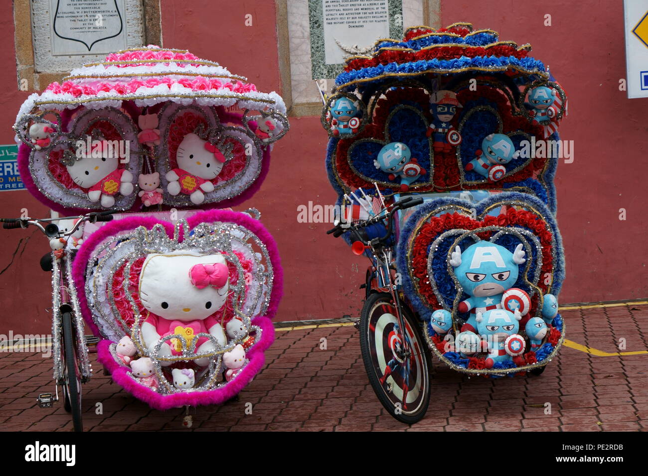 Fahren Sie mit den Rikschas in malacca, die mit farbenfroher Blumenkunst geschmückt sind Stockfoto