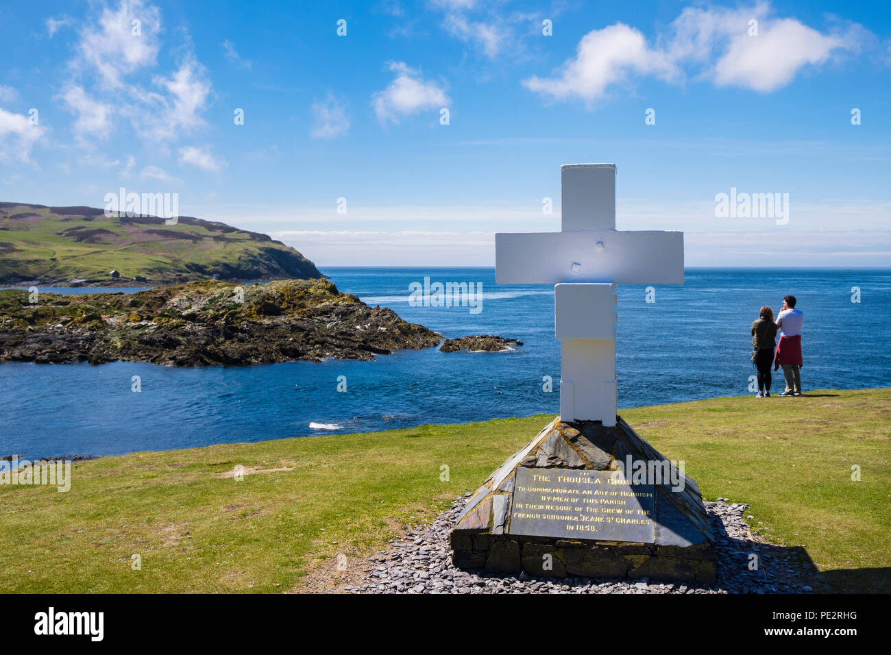 Die Thousla Kreuz an der südlichen Spitze an der Küste mit Blick auf Kalb der Mann Insel mit zwei Personen. Kitterland Insel Man Britische Inseln Stockfoto