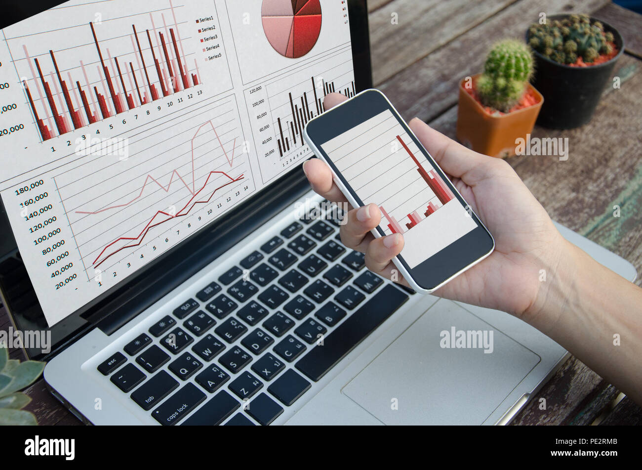 Nahaufnahme der Laptop mit Grafiken, Diagrammen und Tabellen auf dem Bildschirm am Tisch. Stockfoto