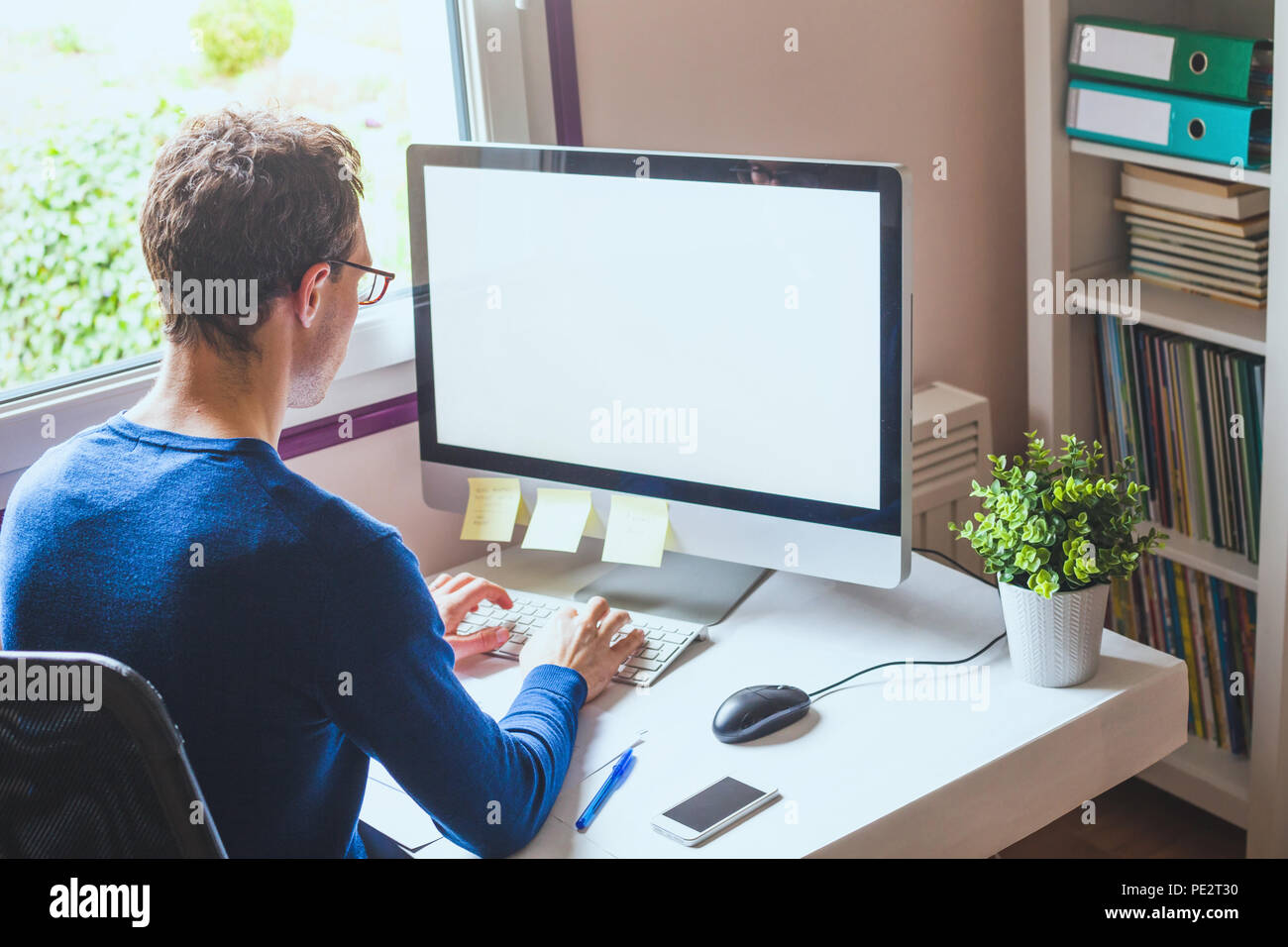 Business Mann bei der Arbeit am Computer mit leeren leerer Bildschirm im Büro Arbeitsplatz Hintergrund Stockfoto
