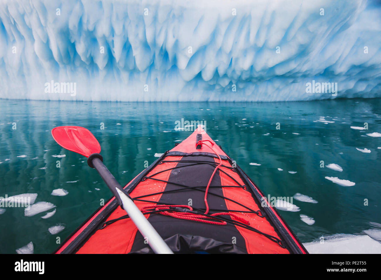 Kajak in der Antarktis, rot Kanu boot mit Paddel in der Nähe von Blue Eisberg Stockfoto